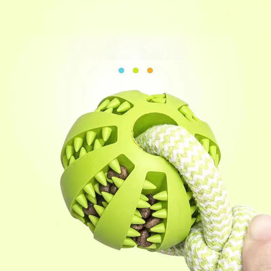 Green dog toy with rope and treats on a light yellow background