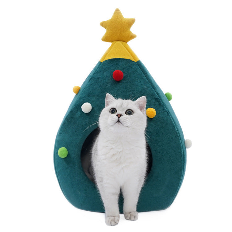 Cat sitting inside a Christmas tree-shaped pet bed on a white background