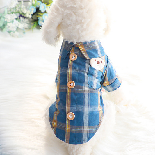 Pet outfit with blue plaid pattern and teddy bear design on a fluffy white background