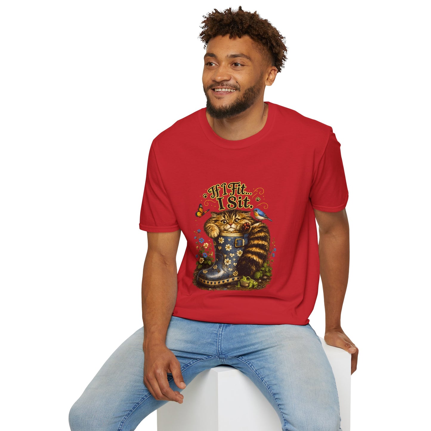 A man sitting on a cube, wearing an red graphic T-shirt of a cat sitting in a rain boot and the text 'If It Fits...I Sit'.