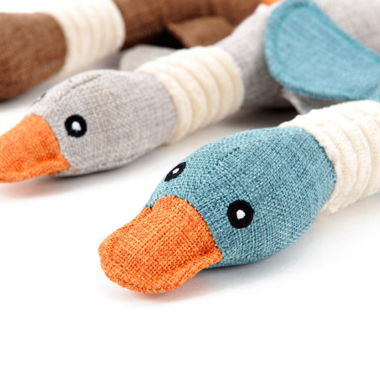 Close-up of knitted duck toys with colorful beaks and feet on a white background
