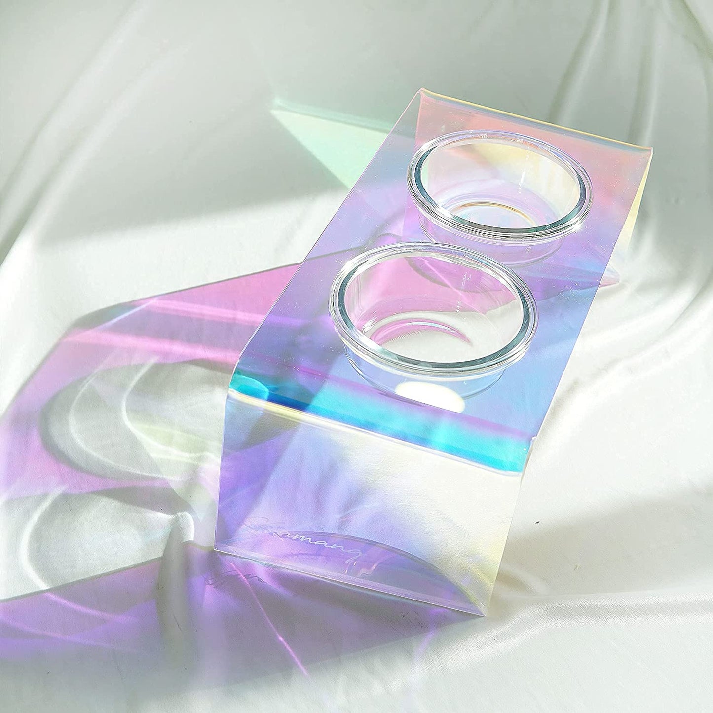 Holographic packaging with two round containers on a white fabric background
