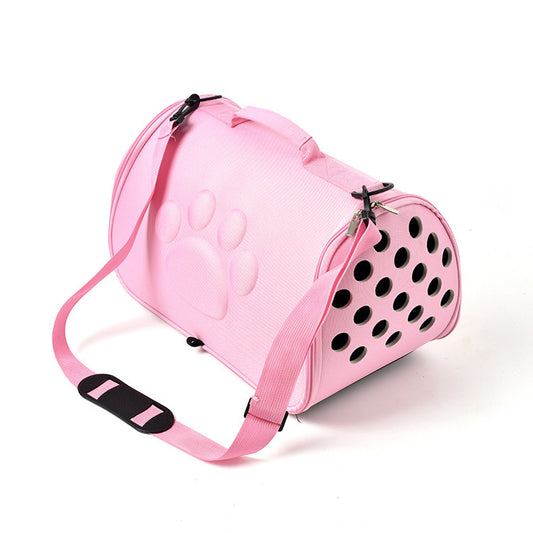Pink pet carrier with black polka dots on a white background