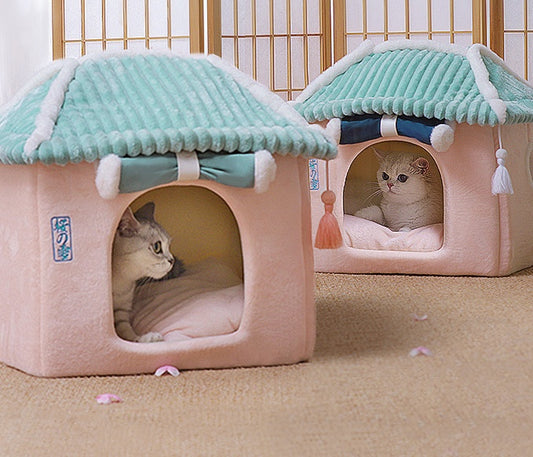 Two cat houses with cats inside on a wooden floor.