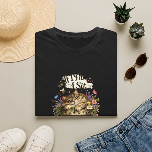 A black folded short-sleeve crewneck t-shirt featuring a vintage-style graphic print of a flower pot with a sleeping cat with a blue bird and the text 'If I Fit... I Sit' on the front, displayed against a solid white background.