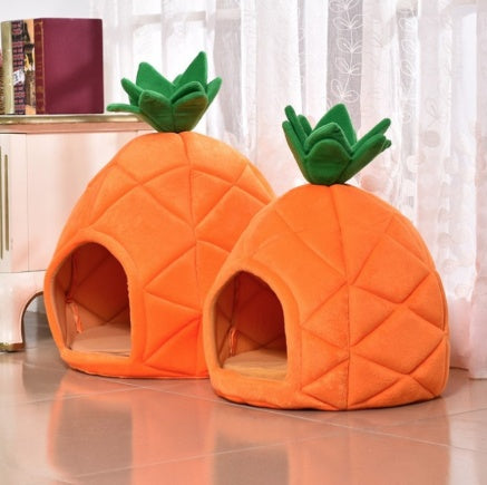 Two pineapple-shaped pet beds on a reflective surface with a blurred background.