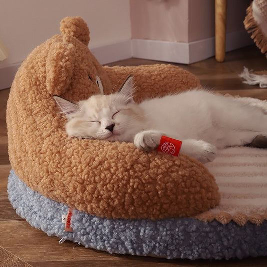 Cat sleeping on a fluffy brown and blue pet bed with a tag.