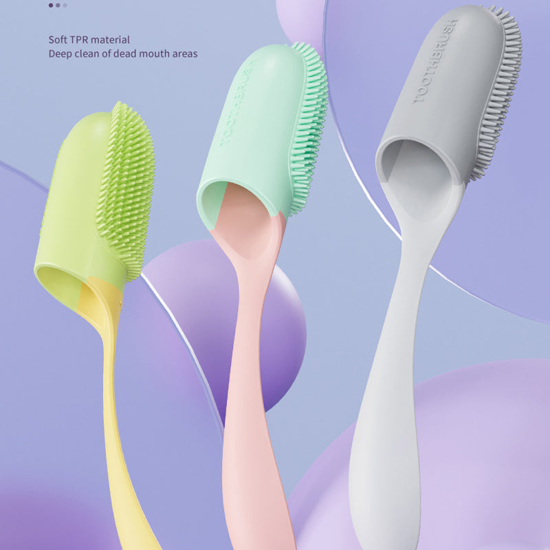 Three silicone toothbrushes in green, pink, and gray on a colorful abstract background.
