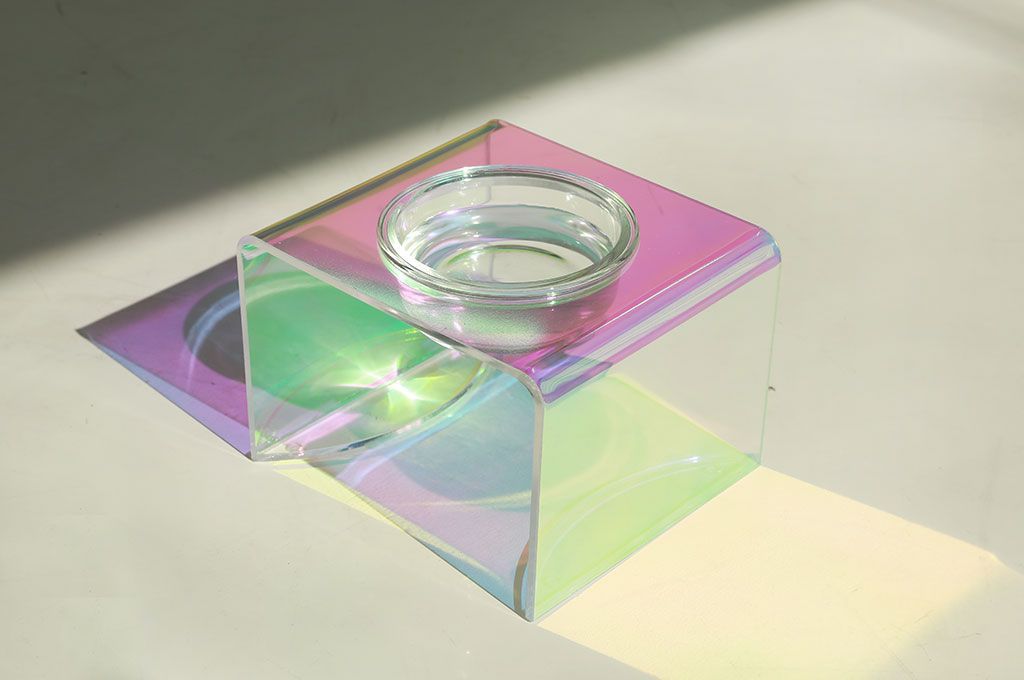 Iridescent glass block with a candle inside on a light background