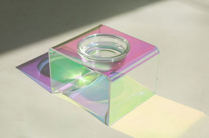 Iridescent glass block with a candle inside on a light background