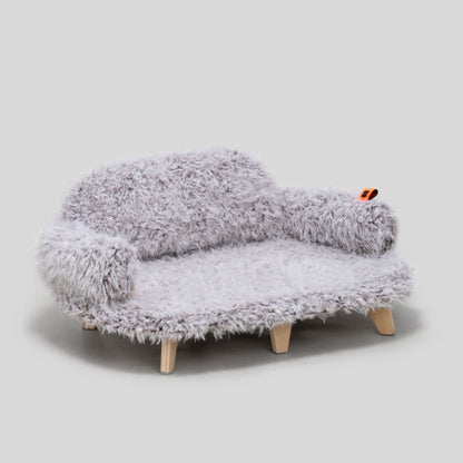 Gray fuzzy sofa with wooden legs on a light gray background