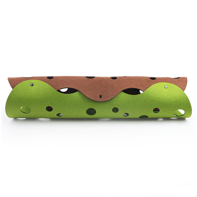 Toy hot dog with green bun and brown top on a white background