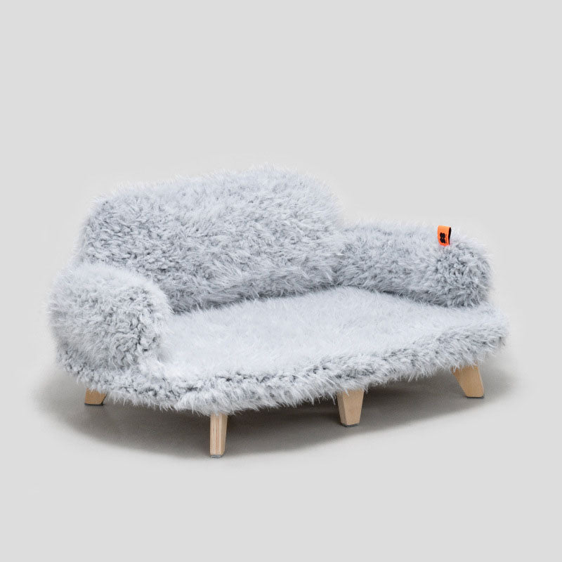Fluffy blue chair with wooden legs on a light gray background
