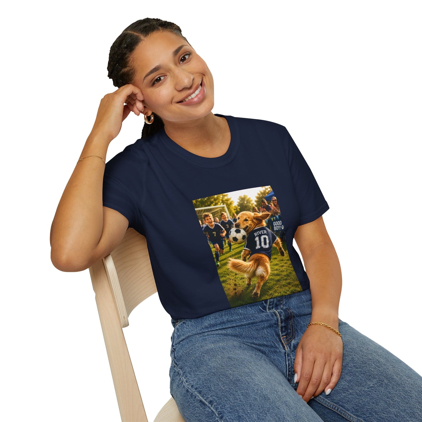 A woman sitting on a light wood chair wearing a navy blue graphic t-shirt with a custom pet soccer print and blue jeans, photographed against a solid white background.