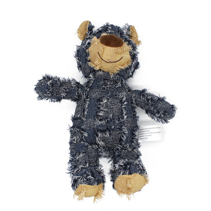 Plush toy resembling a bear in a dark blue onesie with beige accents on a white background