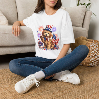 Person wearing a white t-shirt with a bear graphic and American flag design, sitting on a couch.