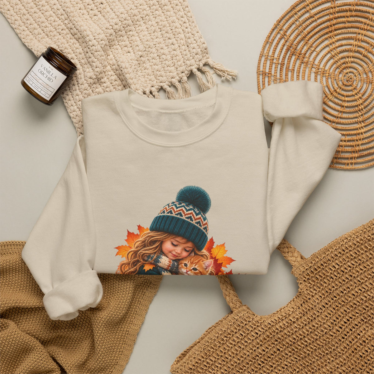 Folded sand Golden Moments girl and kitten sweatshirt styled with neutral knit accessories