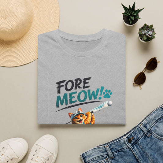 A folded light gray T-shirt with a colorful 'FORE MEOW!' graphic and a cartoon cat is shown in a styled flat lay with a straw hat, white sneakers, sunglasses, and blue jeans on a beige background.