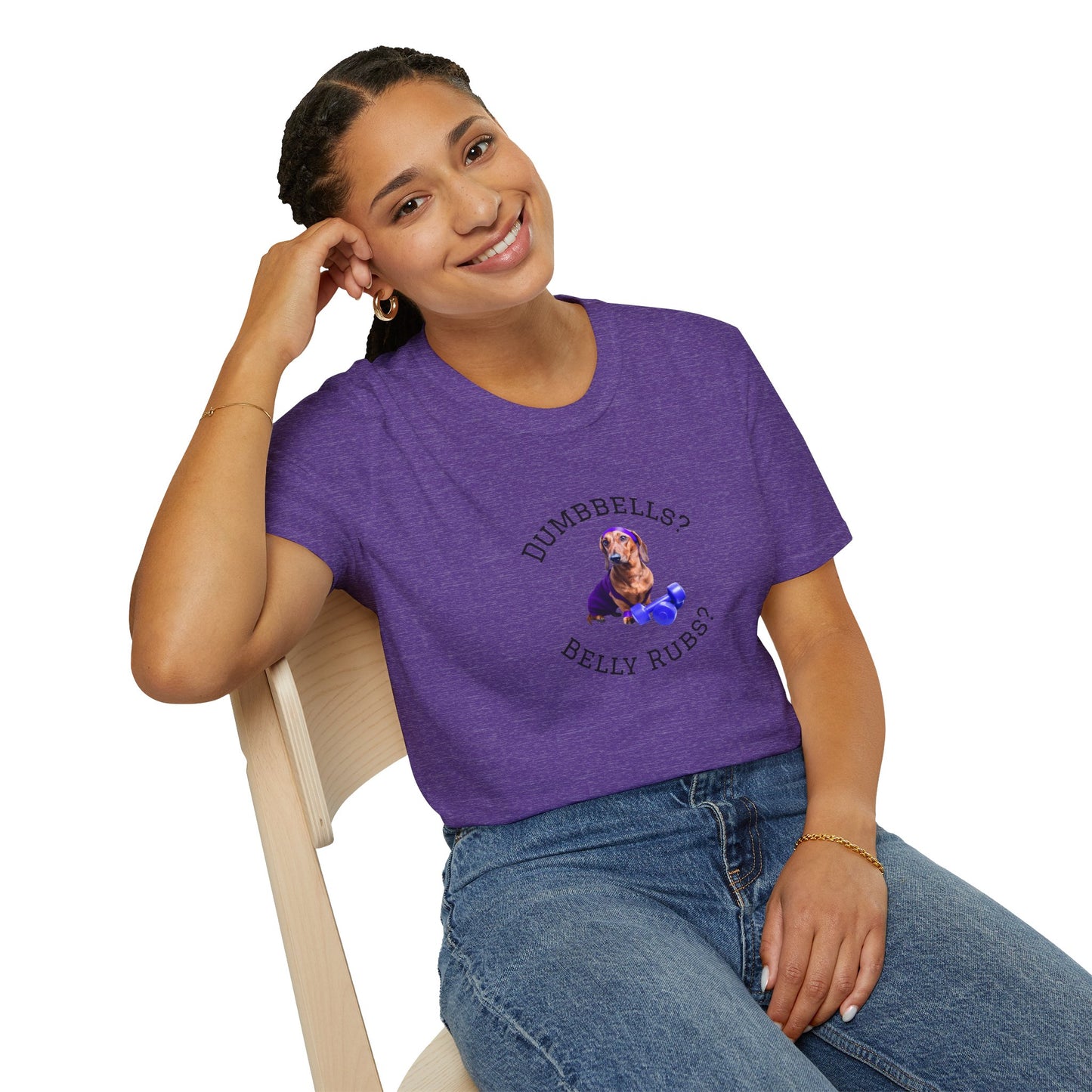 Person wearing a purple t-shirt with a graphic and text, sitting on a chair.