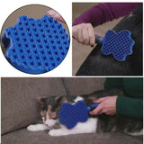 Blue pet grooming brush with textured surface, used on a cat and a person's arm.