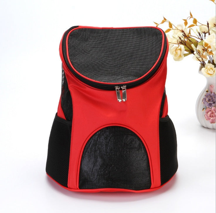 Red and black pet carrier on a white background with a vase of flowers.