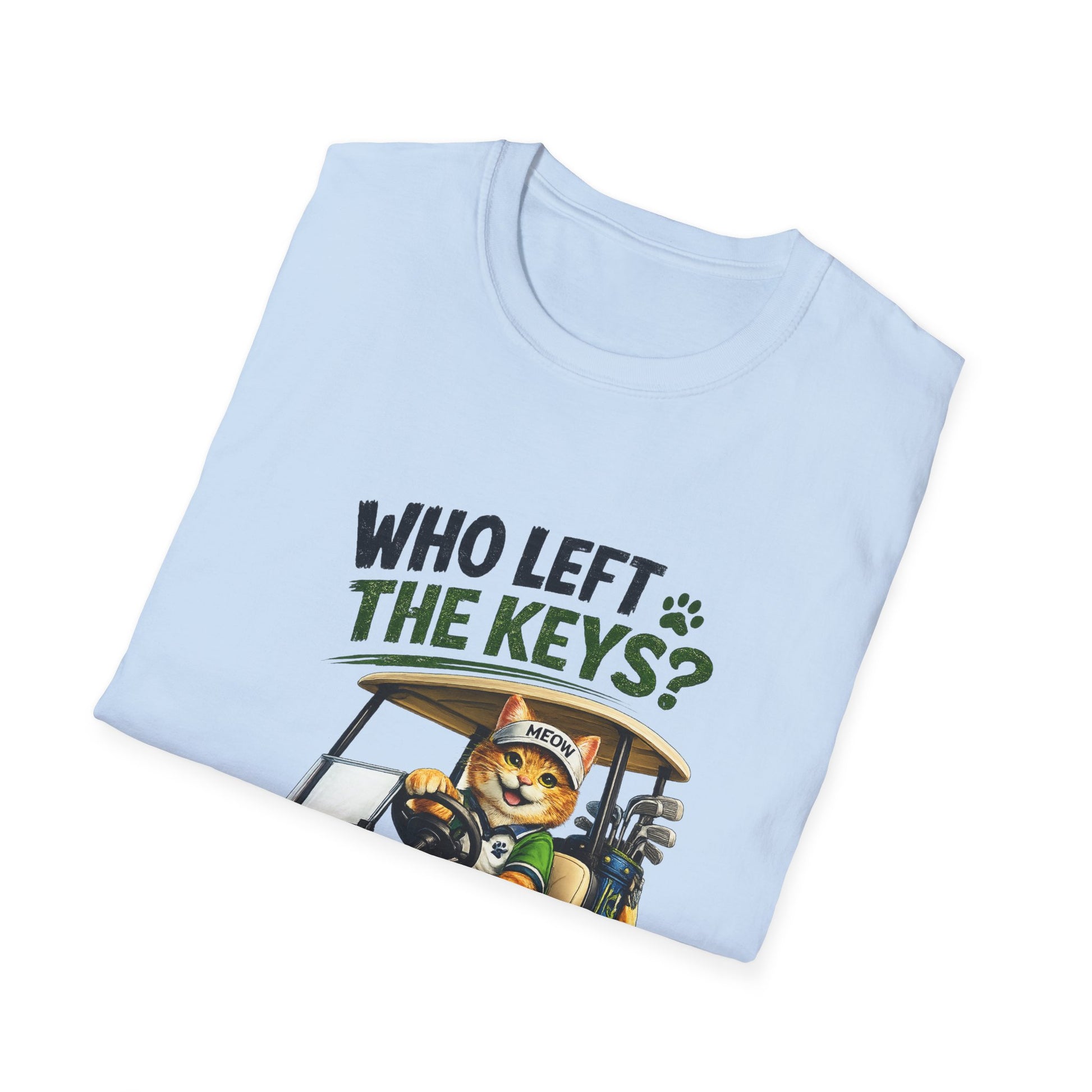A light blue folded t-shirt with a graphic print of a cartoon cat driving a golf cart, with the text 'WHO LEFT THE KEYS?' in black and green.