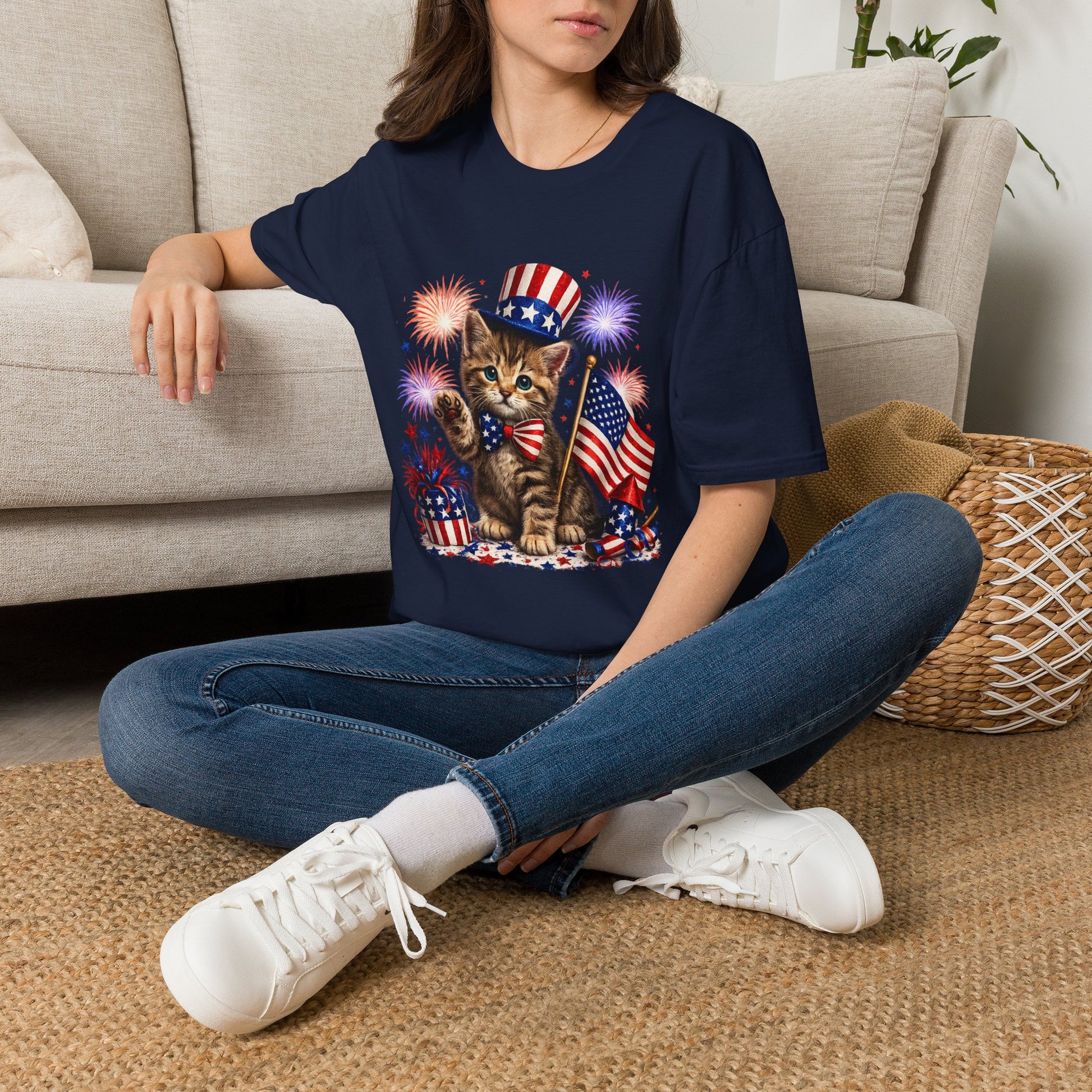 Person wearing a navy blue t-shirt with a cat graphic sitting on a carpeted floor.