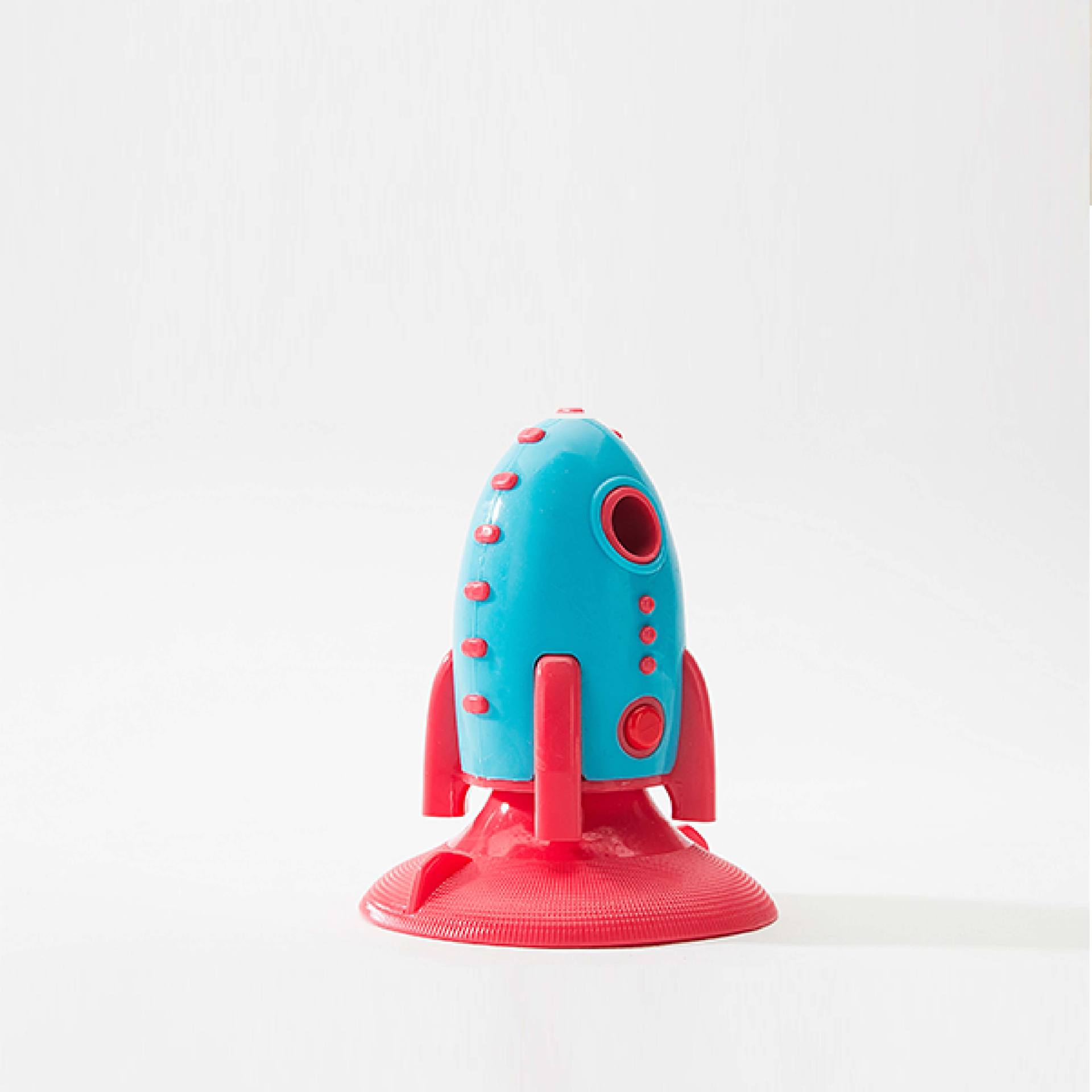 Toy rocket with blue body and red accents on a white background