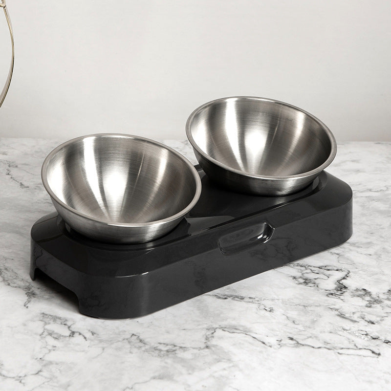 Stainless steel pet bowls on a black elevated stand on a marble surface