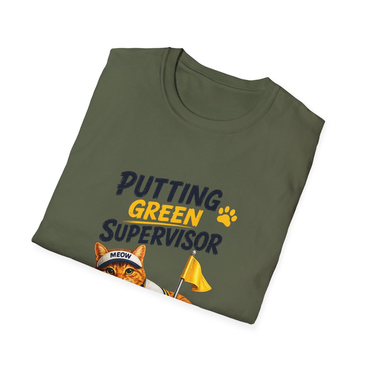 An olive green folded t-shirt with a graphic print that reads 'PUTTING GREEN SUPERVISOR' in navy and yellow, featuring an orange tabby cat wearing a 'MEOW' cap and holding a yellow flag.