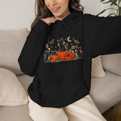 A black pullover hoodie with a front graphic of black cats sitting on orange pumpkins, surrounded by small bats, leaves, and a crescent moon, shown on a plain white background.