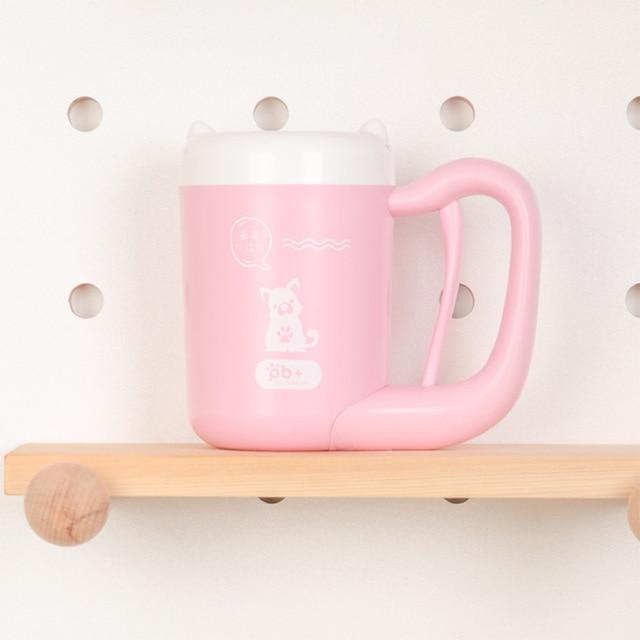 Pink mug with handle on a wooden shelf against a white background