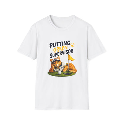 A white short-sleeve crewneck t-shirt featuring a cartoon graphic of an orange tabby cat dressed as a golf supervisor, lying down next to a golf ball and flag on a green putting green, with the text 'PUTTING GREEN SUPERVISOR'.
