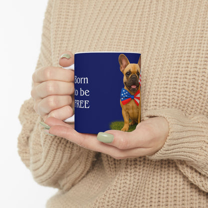 Person holding a blue mug with a dog wearing an American flag bandana and text 'Born to be Free'.