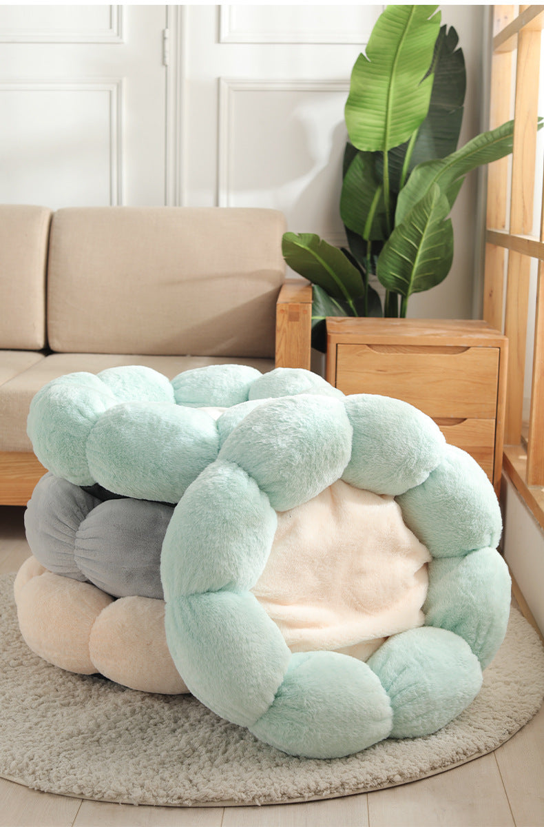 Round, plush pet bed with a soft texture in a living room setting.
