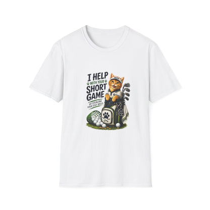 A  white graphic T-shirt is displayed in a styled flat lay on a light beige surface. The shirt features a cartoon cat wearing a baseball cap and holding golf clubs, with the text 'I HELP WITH YOUR SHORT GAME BY STEALING GOLF BALLS.
