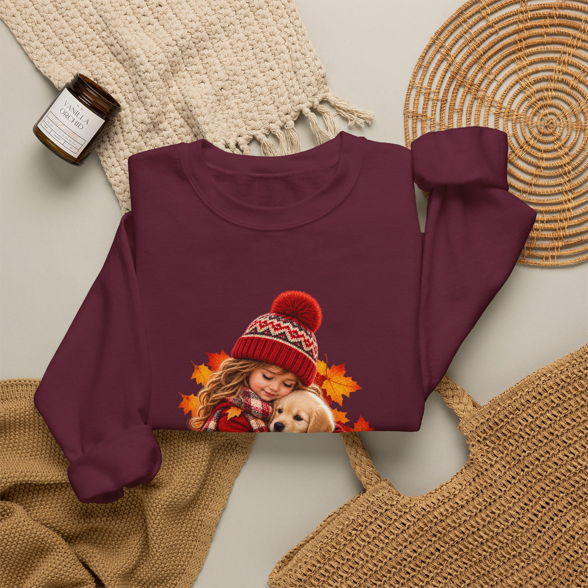 Folded maroon Golden Moments girl and puppy sweatshirt styled with neutral knit accessories