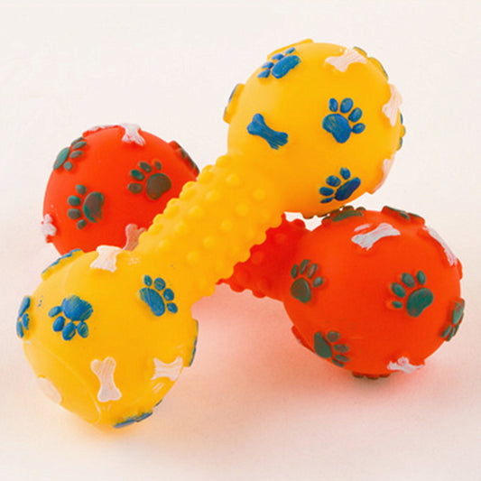 Yellow and orange dog toy shaped like a bone with paw prints on a white background