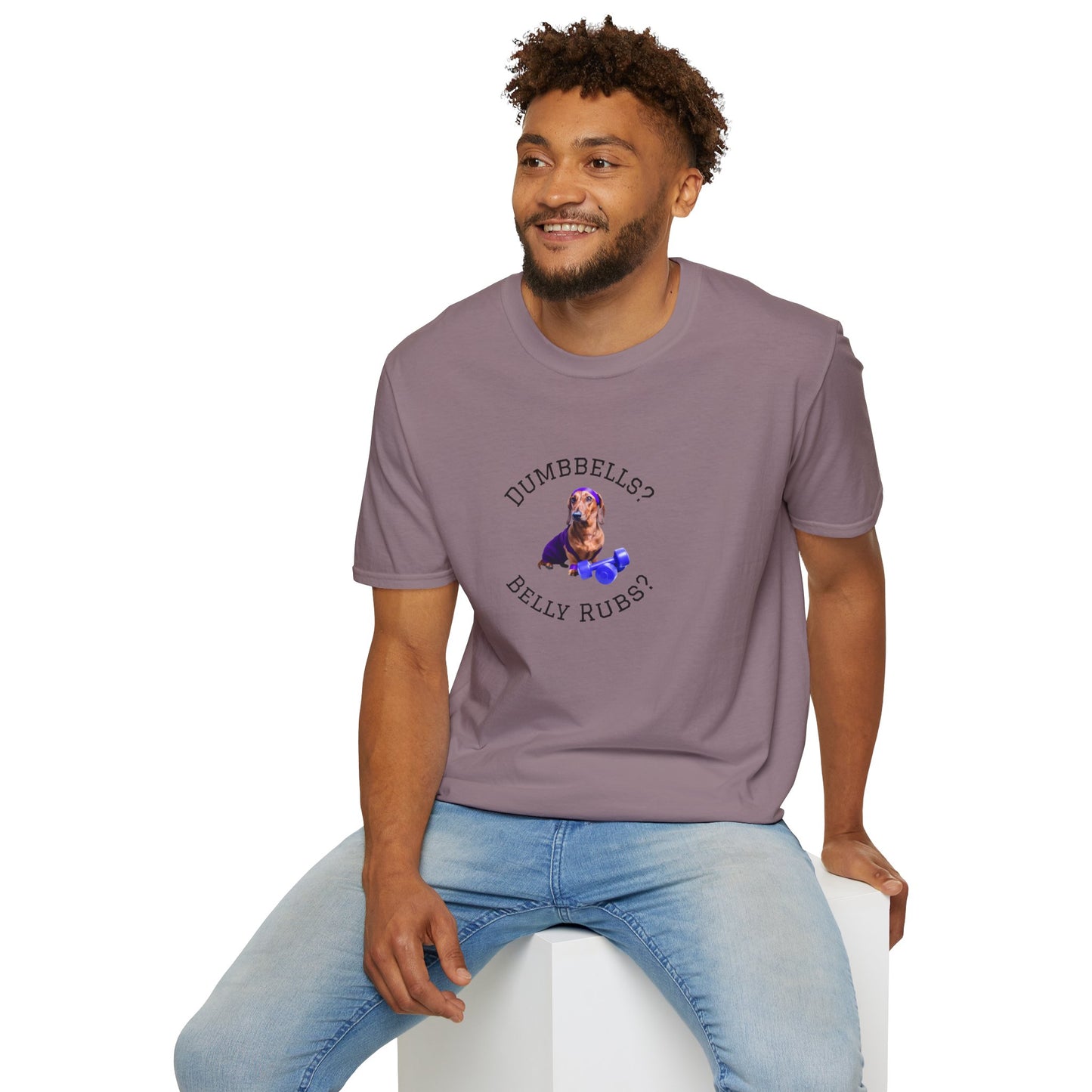 Man wearing a purple t-shirt with text and graphics, sitting on a white stool against a white background.