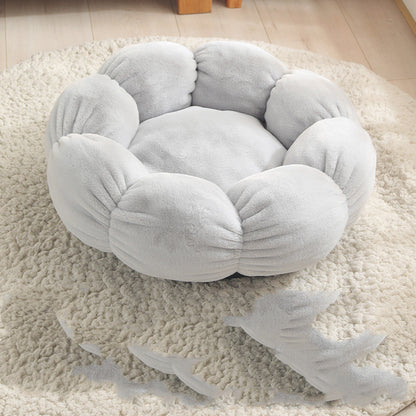 Round, plush pet bed on a fluffy rug with shark toys nearby