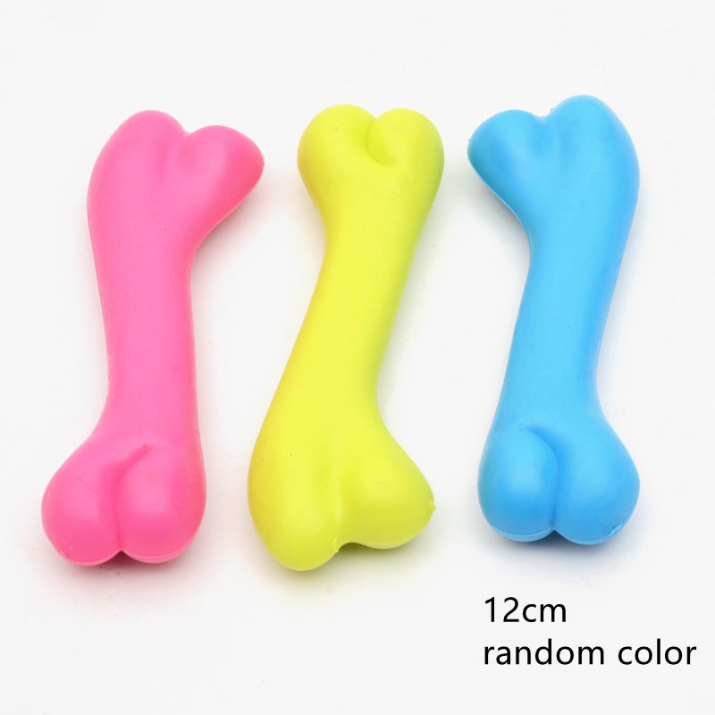 Three colorful bone-shaped toys in pink, yellow, and blue on a white background.