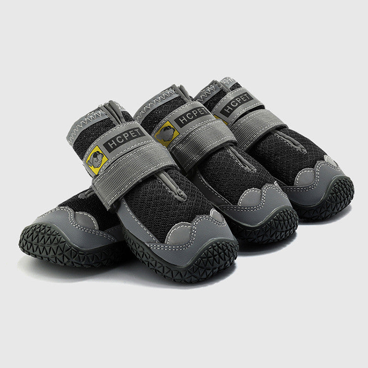 Four black and gray pet boots with brand logo on a light gray background