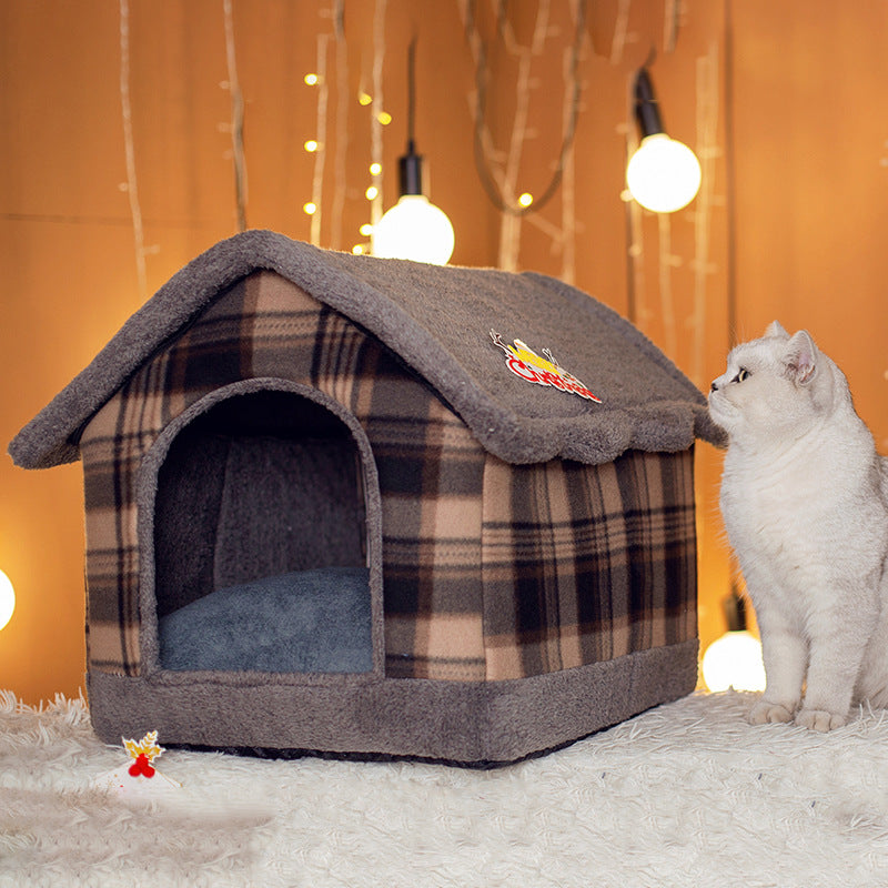 Plaid pet house with a cat sitting next to it against a warm-toned background