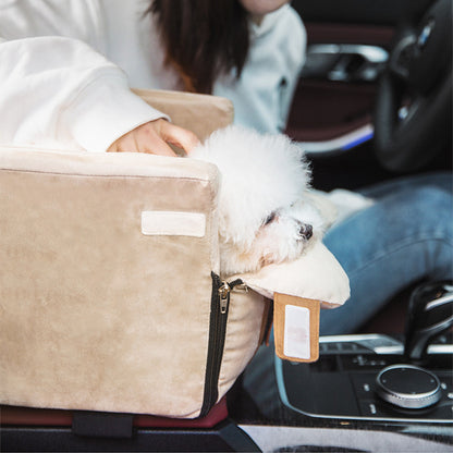Small white dog peeking out from a beige pet seat in a car.