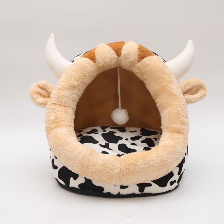 Pet bed designed like a cow with horns and a cow print base on a white background