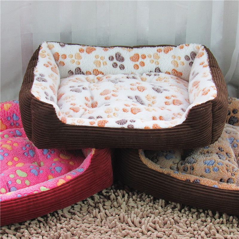 Three pet beds with paw print patterns on a carpeted floor.