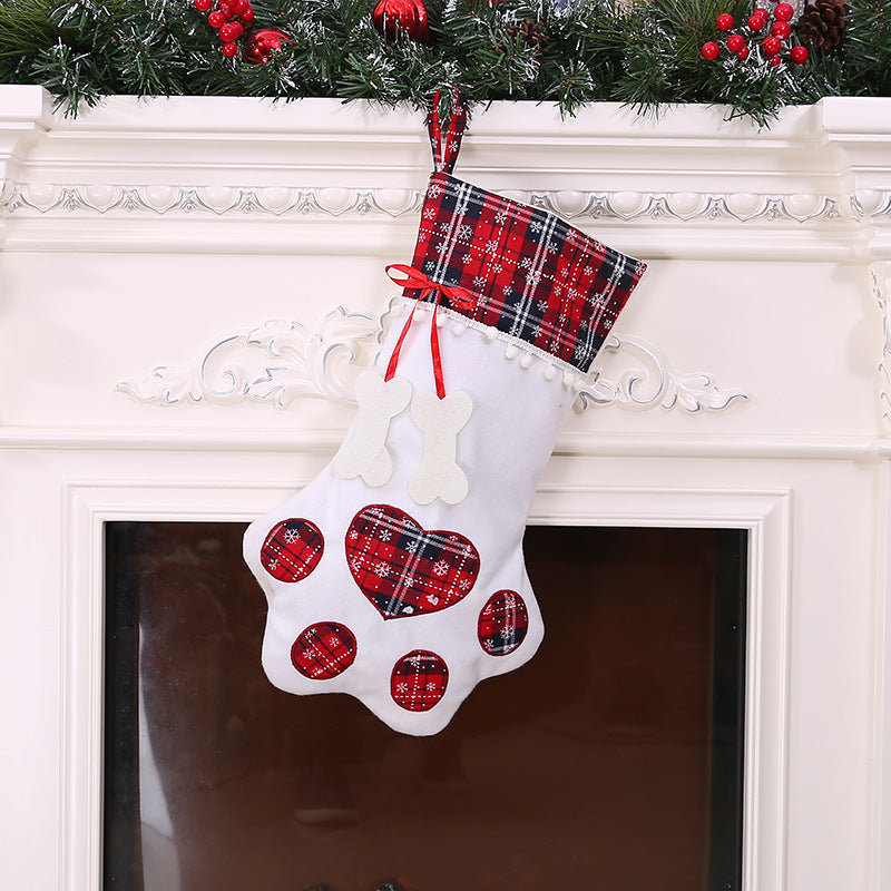 White paw-shaped Christmas stocking with red plaid cuff, matching paw pads, and red ribbon