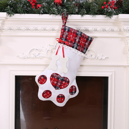 White paw-shaped Christmas stocking with red plaid cuff, matching paw pads, and red ribbon