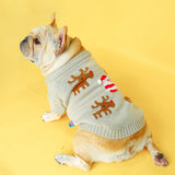 Dog wearing a sweater with reindeer patterns on a yellow background