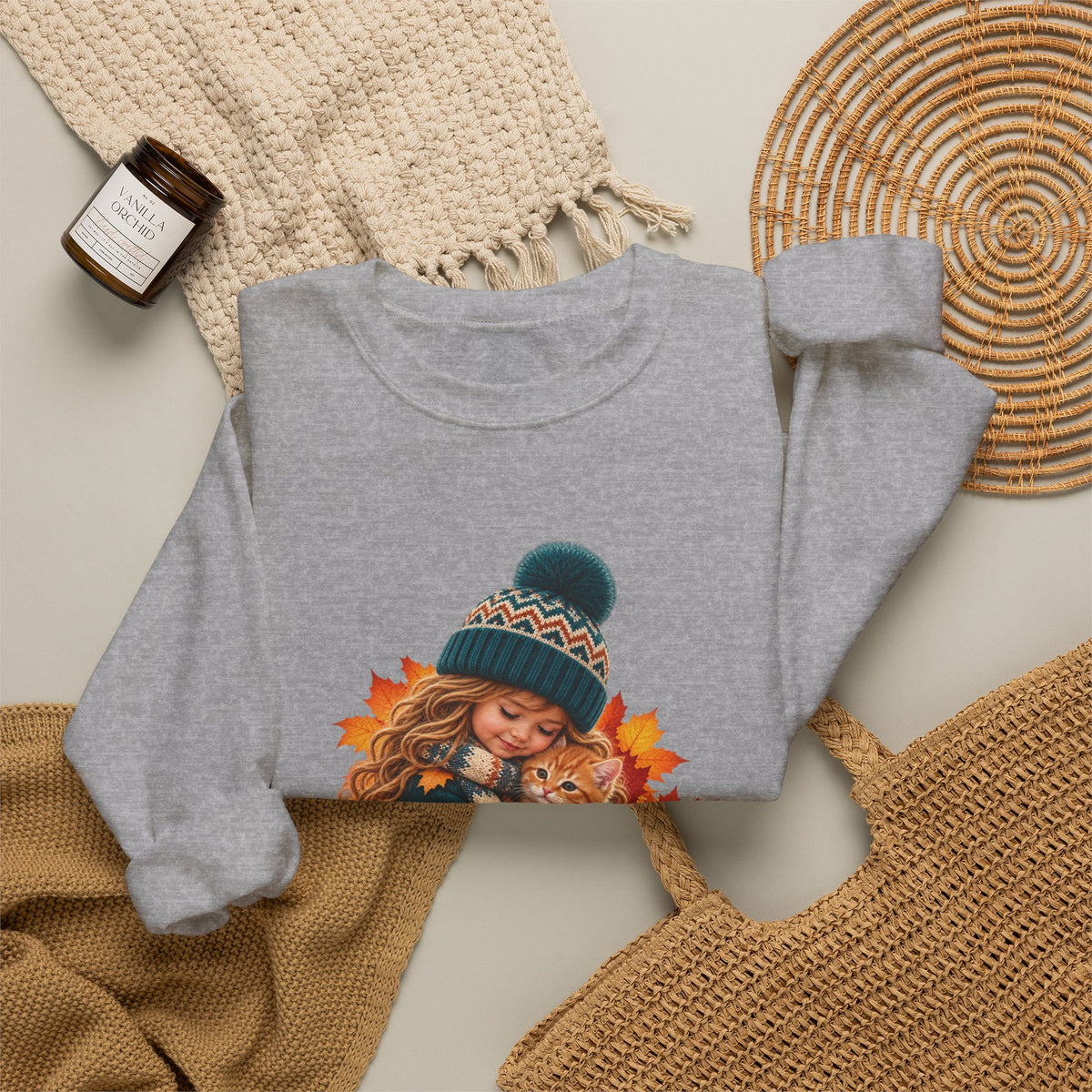 Folded sport grey Golden Moments girl and kitten sweatshirt styled with neutral knit accessories